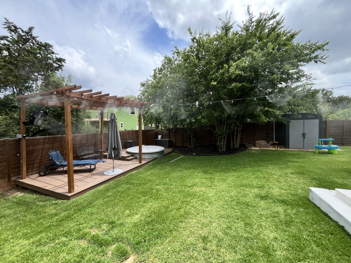 Cedar Park backyard with a pergola-mounted Big Tex misting fan cooling the patio and open lawn