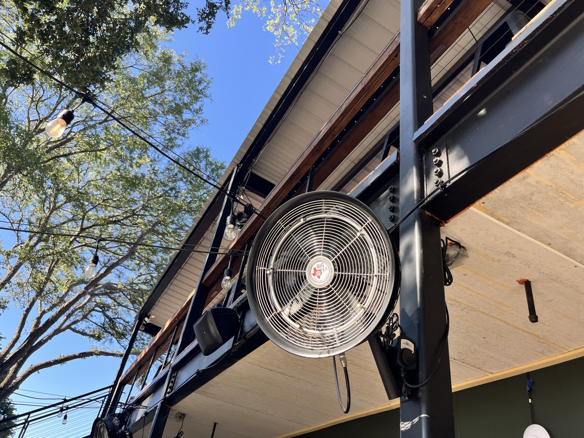 Close-up of a Big Tex high-pressure misting fan mounted under the patio roof at Solstice