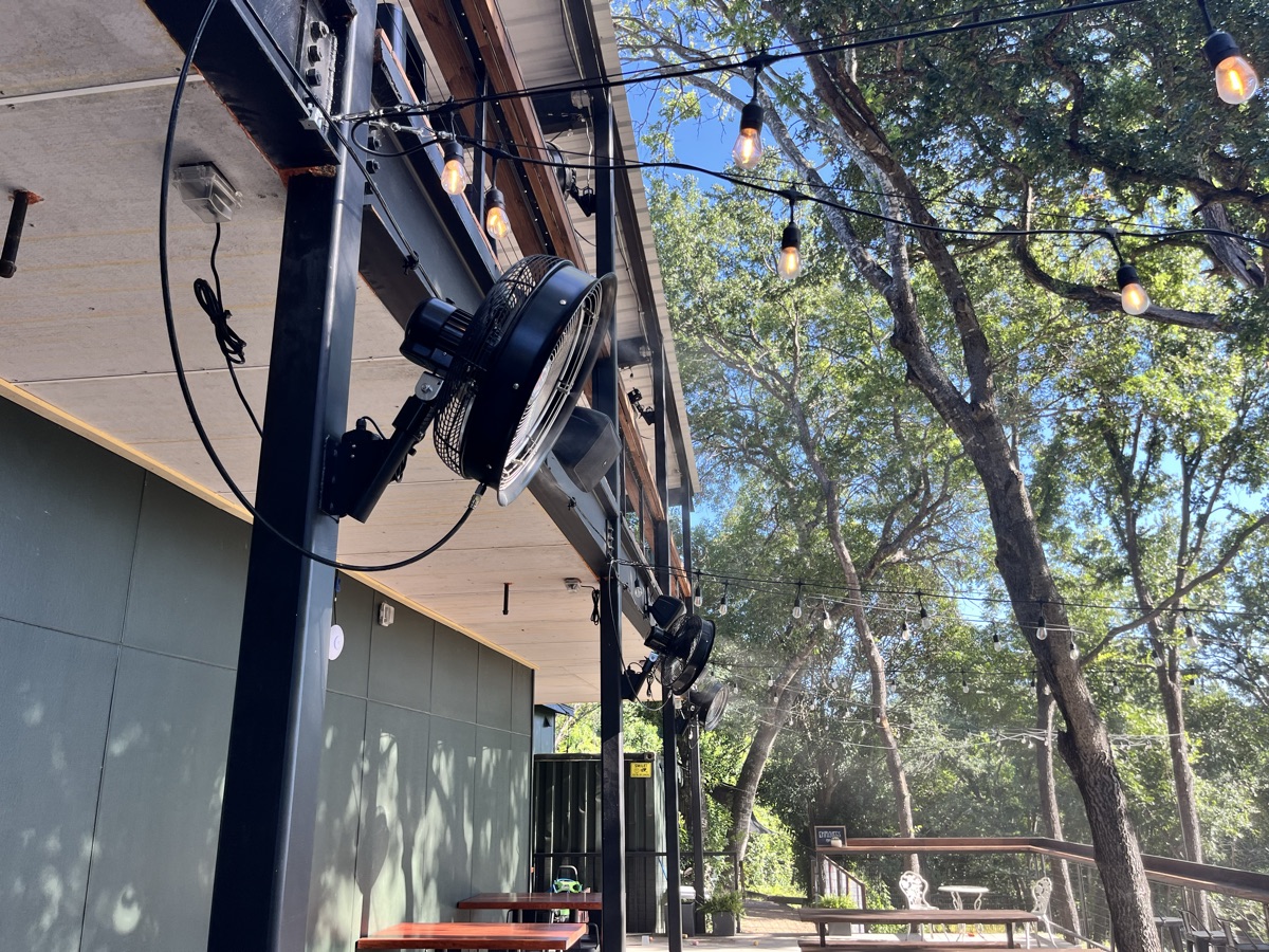 The open-air seating and string lights at Solstice with misting fans throughout