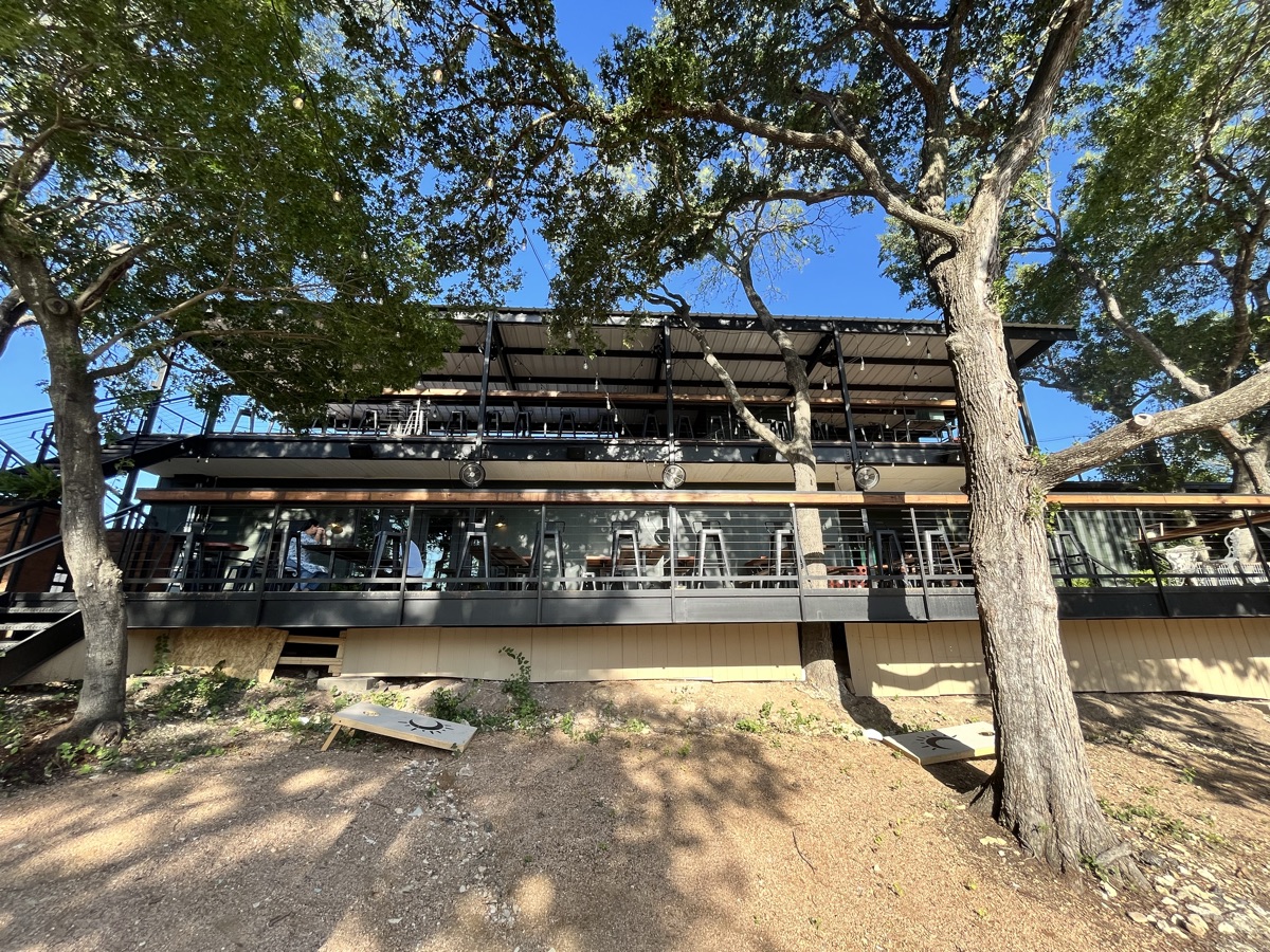 The two-level outdoor patio at Solstice in Jonestown, tucked under mature oak trees