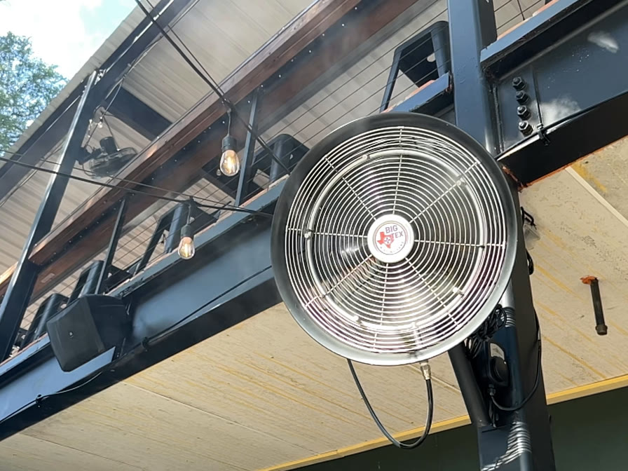 A Big Tex high-pressure misting fan running on the covered patio at Solstice